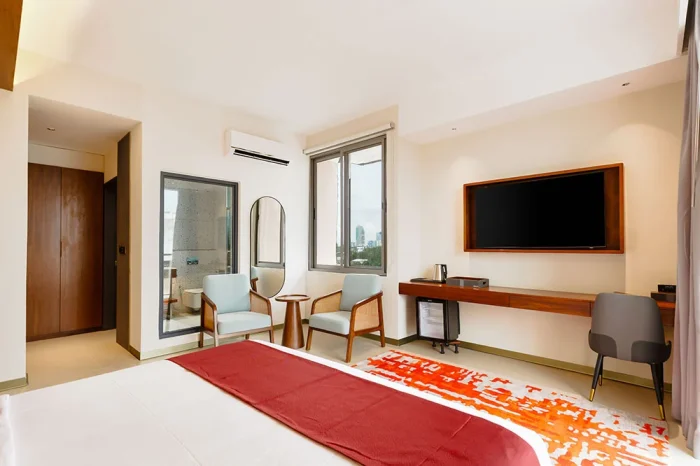 Spacious Deluxe room with a smart TV, comfortable chairs, and a convenient work area.